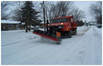 Snow plow going down a residential street